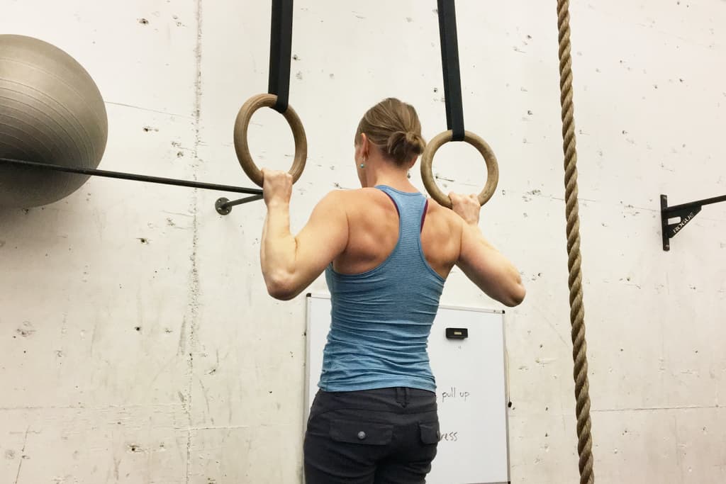 A woman performing a pull up.