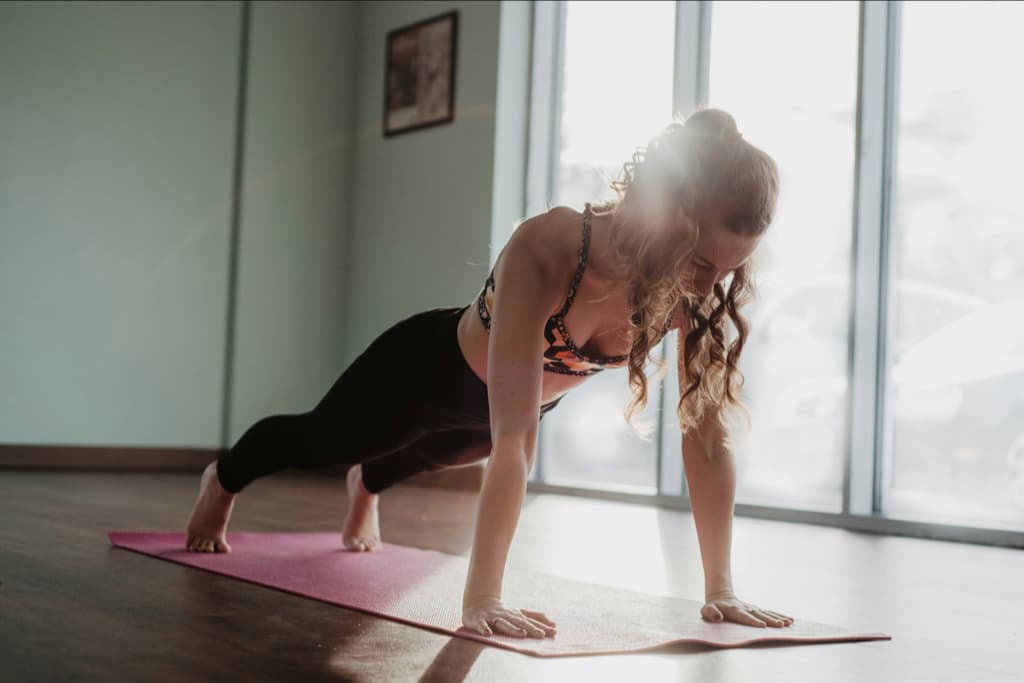 A woman performing a side-plank exercise at home.