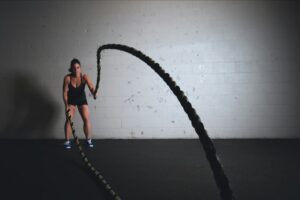 Woman exercising with battle ropes.