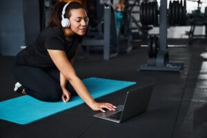 Woman using laptop with online fitness coach.